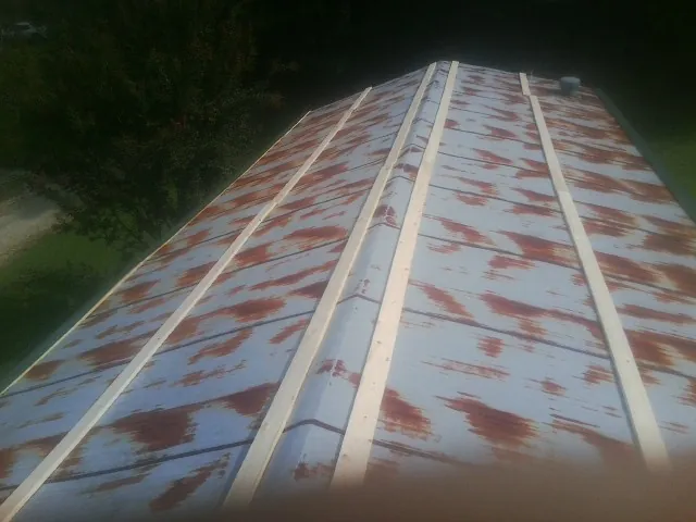 Rusted metal roof panels with new wood purlins before replacement — Storm Damage Roof Repair in Plymouth by Roofing Brothers